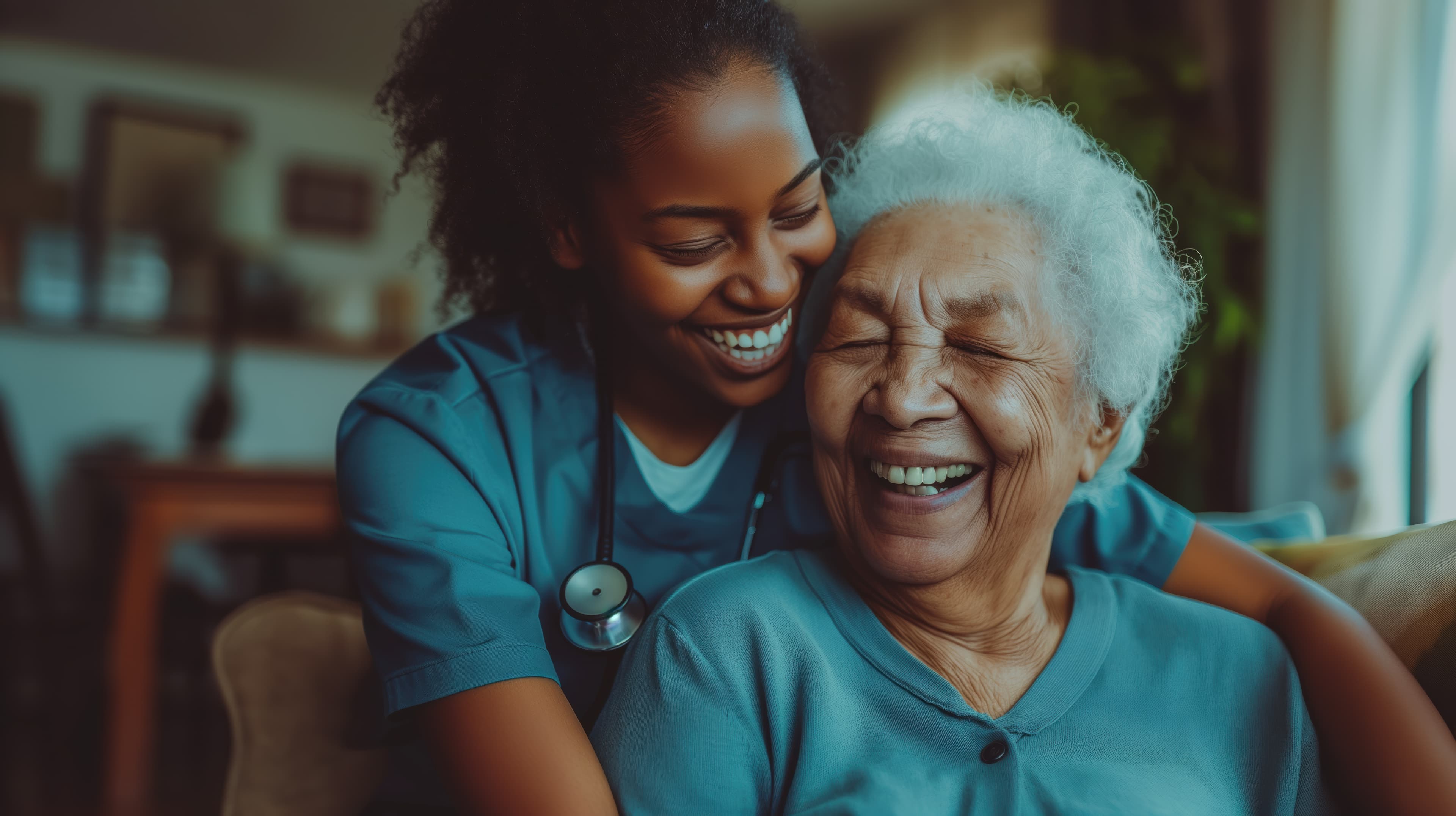 A nurse warmly hugging a laughing older woman at home